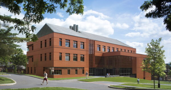 An athletic facilities building with a person walking in front of it.