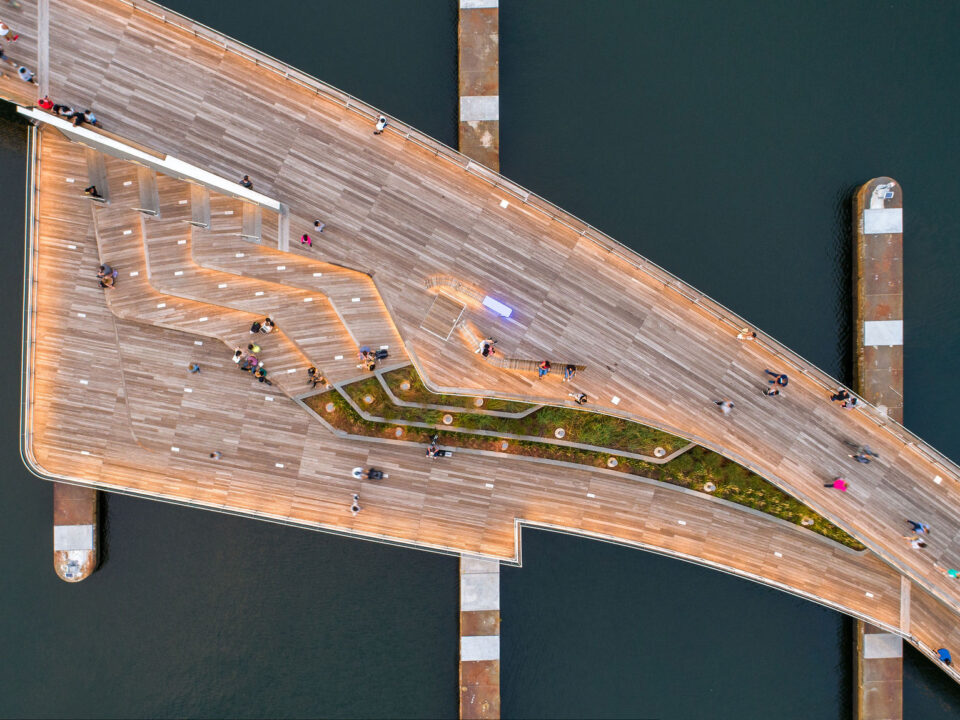 An aerial view of the Michael S. Van Leesten Memorial Bridge with people walking on its wooden walkway.