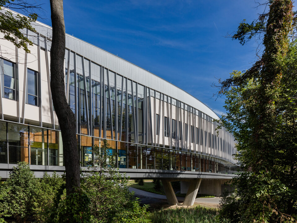 A modern Integrated Science Commons building surrounded by trees and bushes.