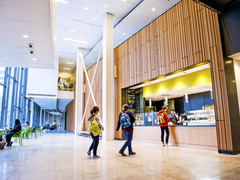 A group of people walking through the Integrated Science Commons lobby.