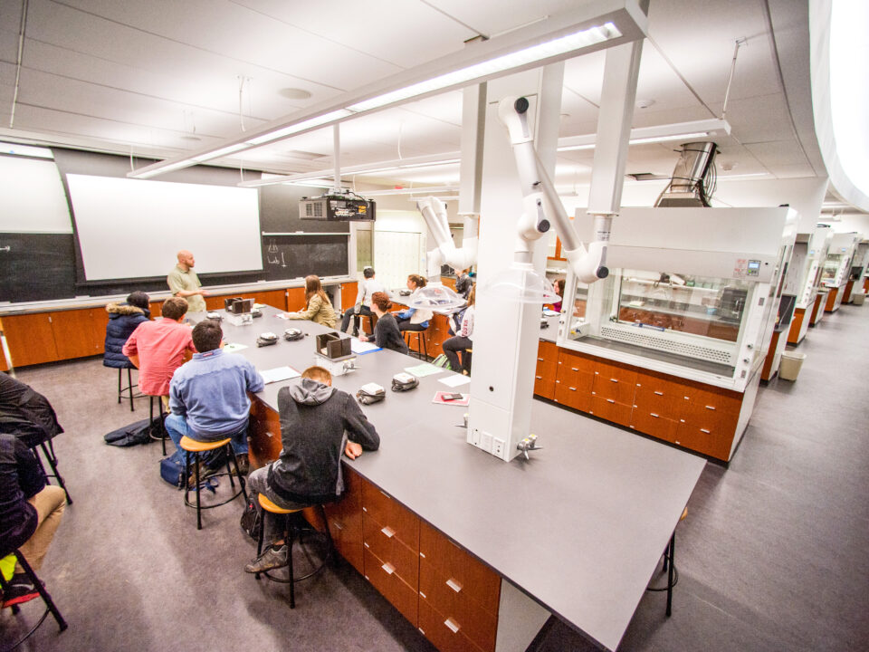 A group of people conducting experiments and collaborative discussions around a table in the Integrated Science Commons.