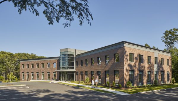 A historic brick building surrounded by lush trees.