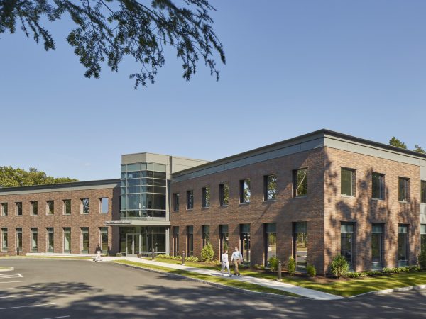 A historic brick building surrounded by lush trees.